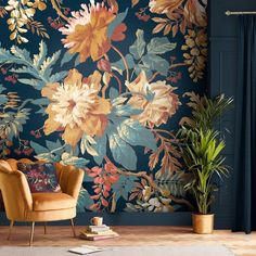 a living room with a floral wallpaper and chair in front of the window, next to a potted plant