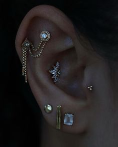 three different ear piercings with pearls on them