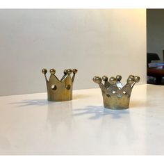 two metal crowns sitting on top of a table