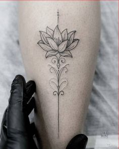 a woman's leg with a flower tattoo on the lower part of her thigh