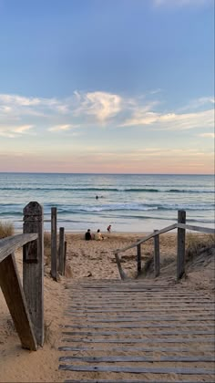 stairs leading to the beach with people in the water