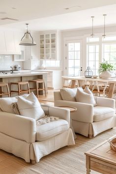 A bright and airy modern farmhouse living room featuring plush beige sofas, natural wood accents, and a seamless transition to the kitchen. Kitchen Furniture