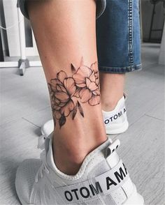 a woman's foot with a flower tattoo on her left ankle and the word mama written in black ink