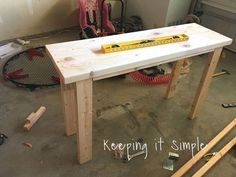 a wooden table sitting in a room with tools on the floor and construction equipment around it