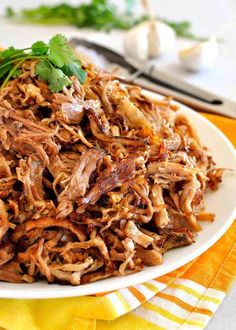 shredded meat on a white plate with parsley