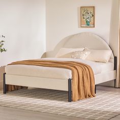 a white bed sitting on top of a wooden floor