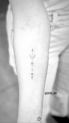 a black and white photo of a person with a tattoo on their arm that has an arrow