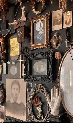 a wall covered in pictures and other items on it's side, including an ornate frame