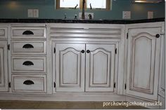 a kitchen with white cabinets and black counter tops