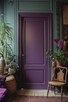 a purple door in the corner of a room with potted plants and a chair