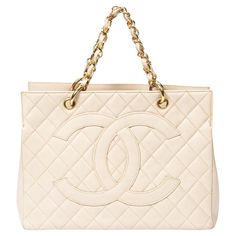 Introducing the Chanel Ivory Grand Shopping Tote: an epitome of timeless elegance. Crafted from luxurious quilted caviar leather in a pristine ivory hue, this tote exudes sophistication. Adorned with gleaming gold hardware, it boasts a classic open-top design for easy access to your essentials. Inside, the leather-lined interior offers ample space for all your belongings. Elevate your ensemble with this iconic piece that effortlessly combines luxury and practicality for the modern woman. Visit o Shopping Tote, Fashion Handbags, Modern Woman, Gold Hardware, The Modern, Timeless Elegance, Dust Bag, Tops Designs, Chanel