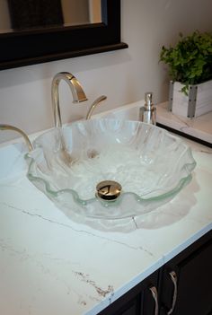 a bathroom sink that has a glass bowl on it