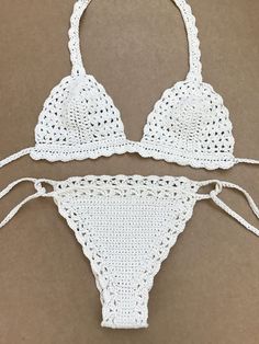 two pieces of white crochet swimsuit on brown background