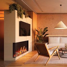 a living room with a couch, chair and fire place in the corner on top of a hard wood floor