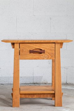 a small wooden table with one drawer open