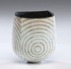 a white and black vase sitting on top of a table