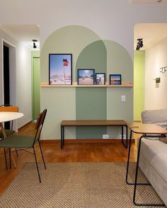 a living room filled with furniture and pictures on the wall next to a wooden floor