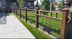 a wooden fence with metal bars on the top and bottom, in front of a house