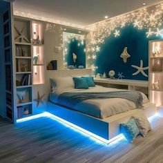 a bedroom decorated in blue and white with starfish lights on the wall above the bed