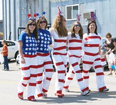 four women dressed in patriotic outfits walking down the street