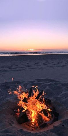 a fire pit on the beach at sunset