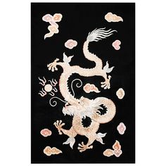 an embroidered dragon with flowers and leaves on the side, is shown in black background