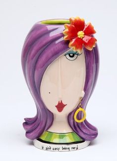 a ceramic figurine with a flower in her hair