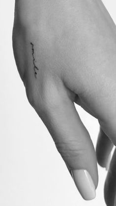 a woman's hand with a small tattoo on it