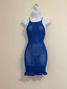 a blue knitted dress hanging on a wall