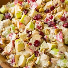 a salad with apples, cranberries and walnuts in it is ready to be eaten