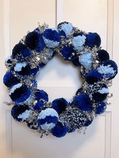 a blue and silver wreath hanging on the front door