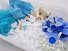 two polar bears in a tub filled with ice and plastic water bottles next to each other