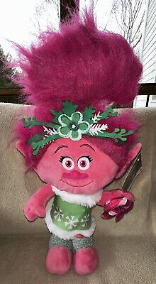 a pink troll doll sitting on top of a couch next to a knife and fork