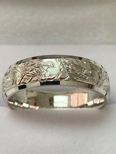 a wedding band that has been engraved with leaves