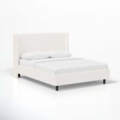 a bed with white sheets and pillows on it