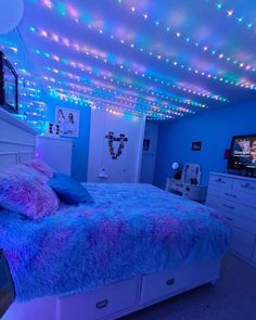 a bedroom with blue and pink lights on the ceiling