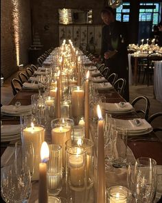 a long table with many lit candles on it