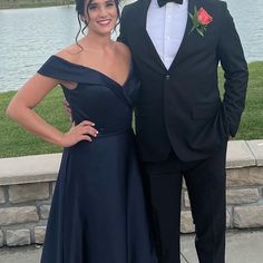 a man in a tuxedo standing next to a woman in a blue dress