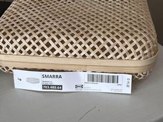 a piece of wicker sitting on top of a table next to a price tag