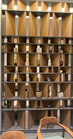 two wooden chairs sitting in front of a book shelf