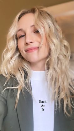 a woman with blonde hair wearing a white t - shirt and black blazer jacket