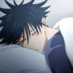 a man with black hair laying in bed