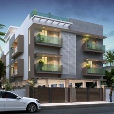 a white car is parked in front of a two story building with balconies