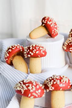 red and white cookies with sprinkles on top of a cake plate,