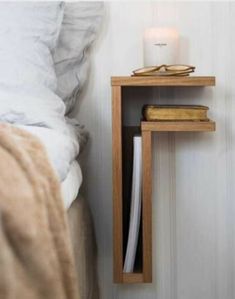 a bedside table with glasses on it next to a bed