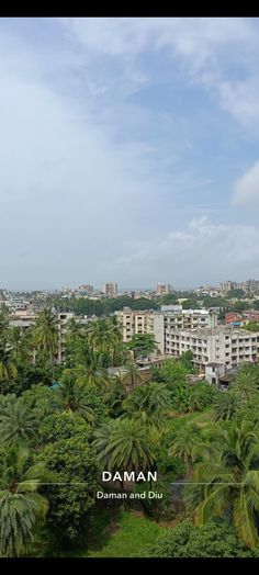 the city is surrounded by palm trees and tall buildings with white lettering that reads daman