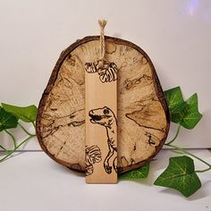 a piece of wood with an image of a dog on it and some leaves around it