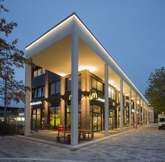 the building is lit up at night with lights on it's sides and windows