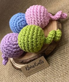 three crocheted hats sitting on top of a wooden object with a tag in front of it