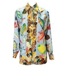 Presenting a baby blue aquatic motif silk button-down Gucci shirt. From the Spring/Summer 1992 collection, this fabulous top appeared on the season's runway and in the season's ad campaign. Covered in shells and different aquatic life, this fabulous shirt is made complete with gold 'GG' Gucci buttons at the neck and cuffs. Approximate measurements: Size - IT38 22.5" shoulder to cuff 19.5" underarm to cuff 28" shoulder to hem 41" bust 41" waist 100% silk Luxury Fitted Gucci Blouse, Gucci Summer Workwear Tops, Luxury Printed Blouse For Spring, Designer Summer Floral Print Shirt, Designer Floral Print Summer Shirt, Designer Long Sleeve Summer Tops, Designer Printed Tops For Spring, Designer Long Sleeve Tops For Summer, Gucci Button-up Shirt For Spring